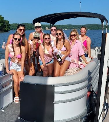 Group of women in swimsuits on a boat on a sunny day.